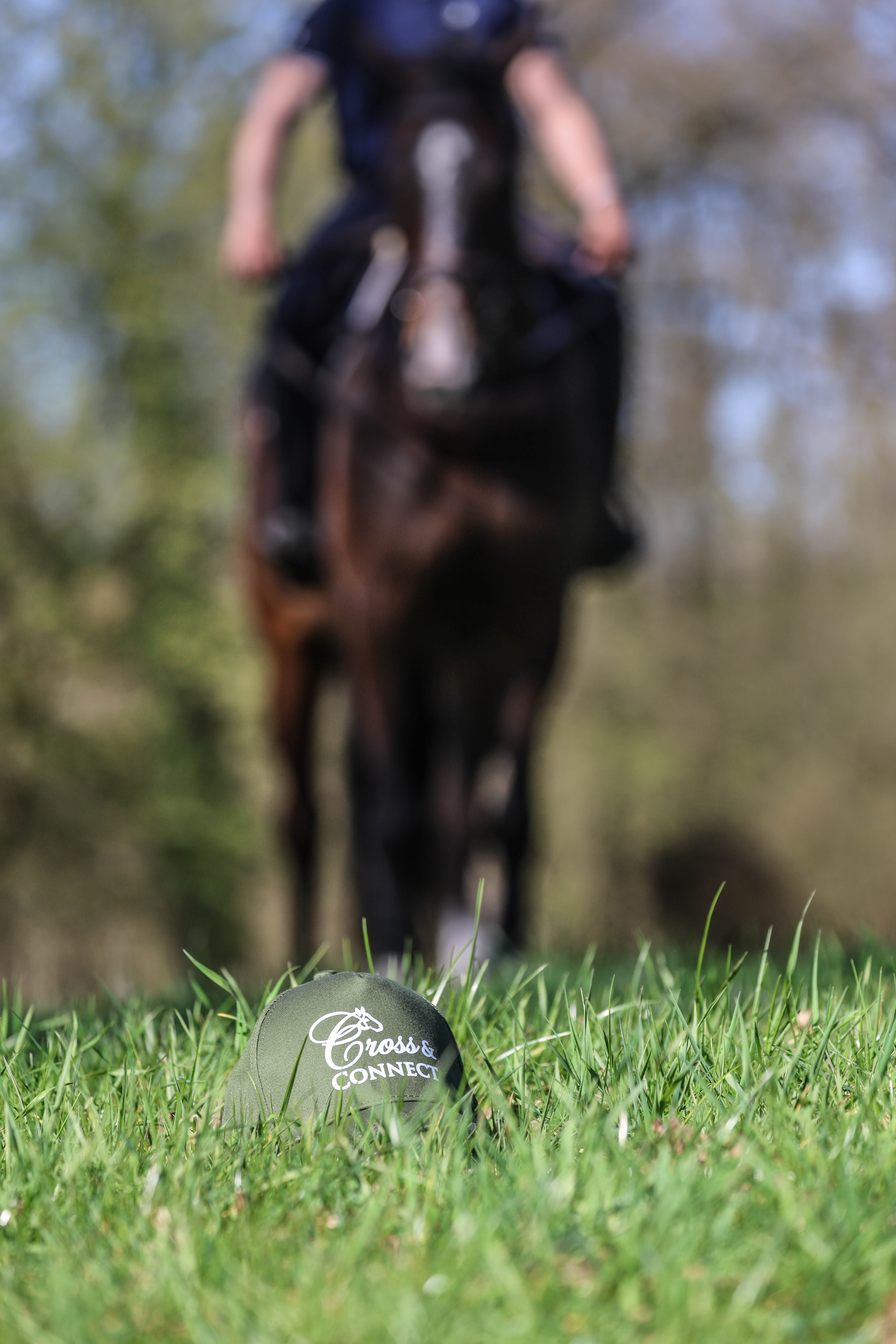 Cross & Connect cap with a rider in the background
